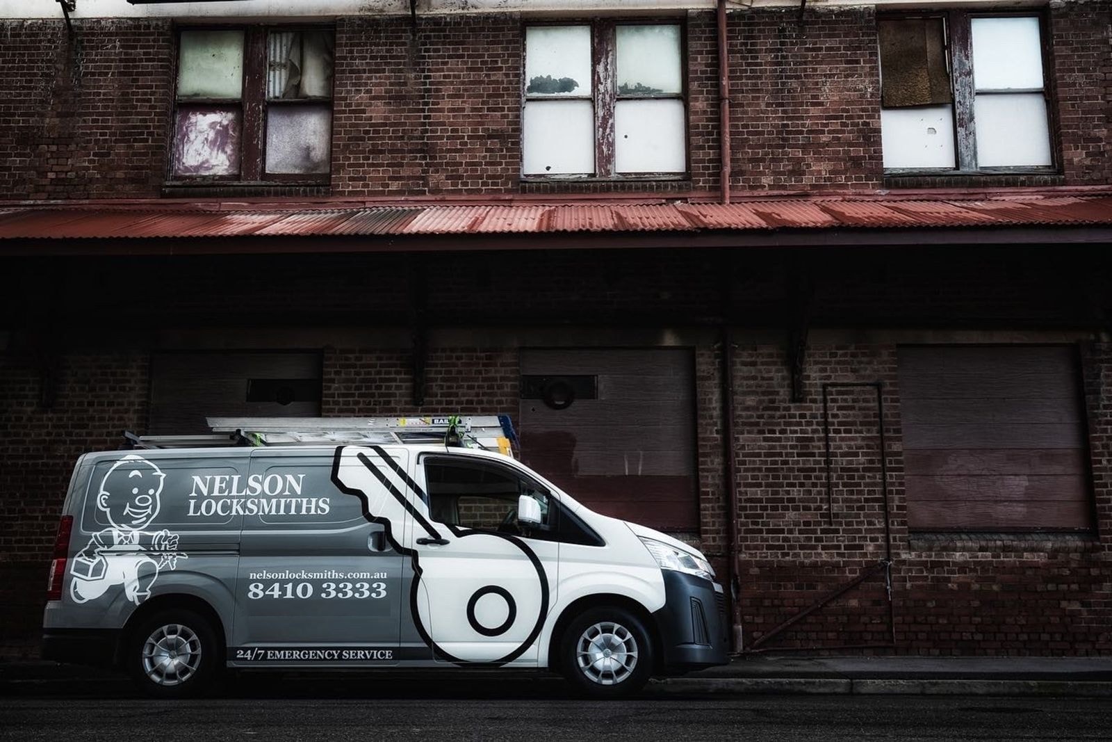 Nelson Locksmiths van parked beside an old brick building